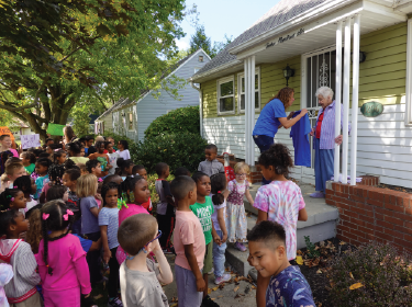 maize students standing outside of house in neighborhood